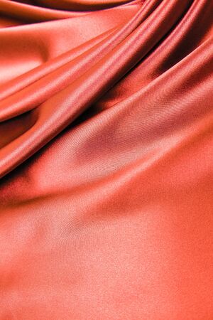 Smooth elegant wavy red silk or satin luxury cloth fabric texture, abstract background design.の写真素材