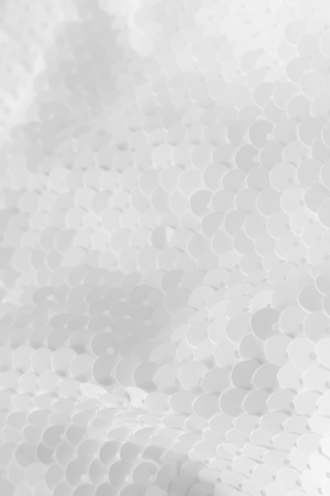 Background sequin. Holiday abstract glitter background with blinking lights. Fabric sequins in white color. Fashion fabric glitter.の写真素材