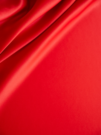 Beautiful smooth elegant wavy hot red satin silk luxury cloth fabric texture, abstract background design. Wallpaper, banner or card with copy space.の写真素材