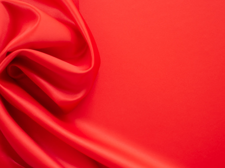 Beautiful smooth elegant wavy hot red satin silk luxury cloth fabric texture, abstract background design. Wallpaper, banner or card with copy space.の写真素材