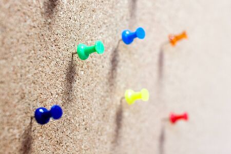 Group of thumbtacks pinned on corkboard.の写真素材