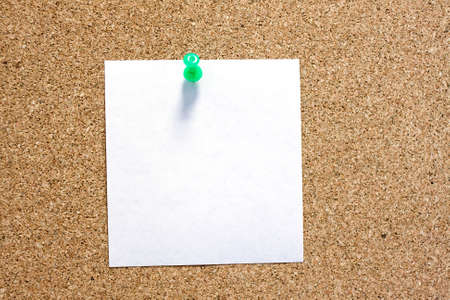 Post-it note with green pushpin on corkboard.の写真素材