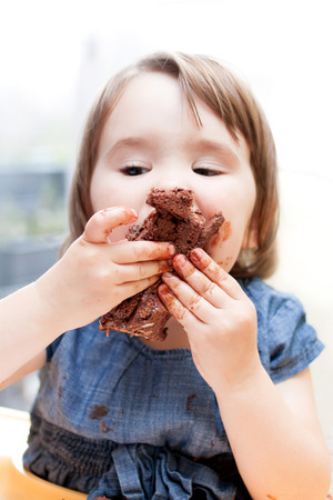 An adorable little girl enjoying her birthday cake.の写真素材