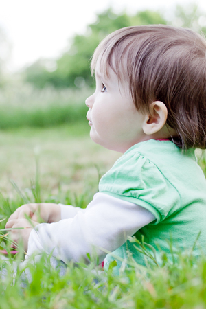 Cute little girl on the meadow in spring day.の写真素材