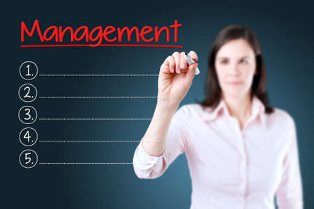Business woman writing blank Management list. Blue background.の写真素材