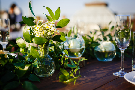 wedding decorations made of wood and wildflowers served on the festive tableの写真素材