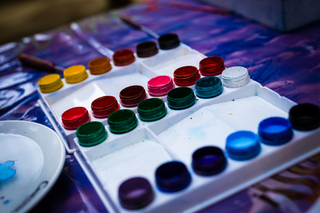 Jars with gouache and paint brushes. On a white backgroundの写真素材
