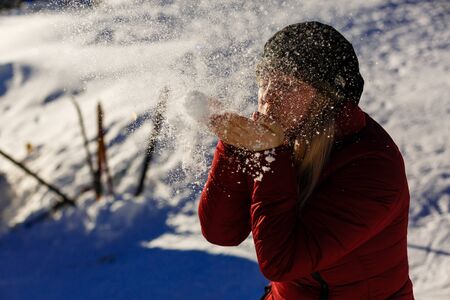 young girl blowing magic snow blows snow from palmの写真素材
