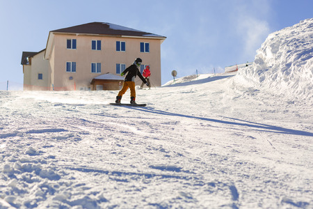 Snowboarder doing a toe side carve with deep blue sky in background snowの写真素材
