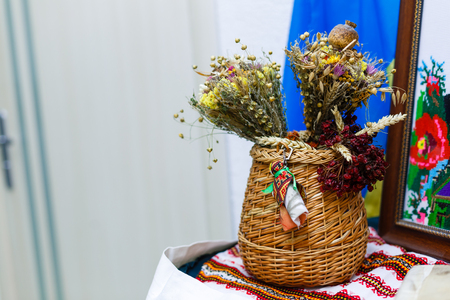 Clay pot covered with a lid and wheat sheaf on the background fabric pattern Ukrainianの写真素材