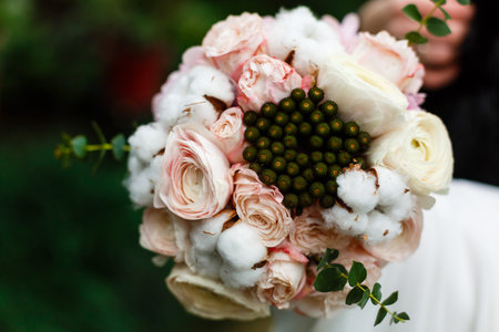 Beautiful winter wedding bouquet with cones, cotton and spruce branches Bruno. Bride holding a...