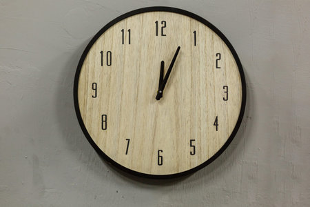 Black and white clock hanging on a leather belts, decorative wall gray background