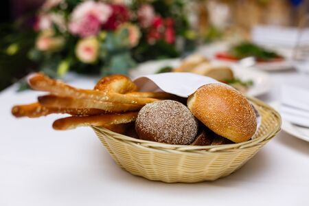 Bread in basket with butter under sunlight Buns bread in a basket tableの写真素材