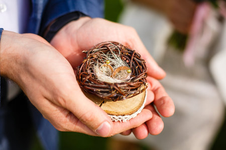 Pair of wedding rings laying in nest. Wedding decoration. Symbol of family, togetherness and loveの写真素材