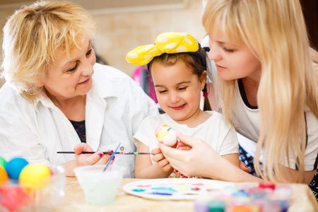 Happy family painting Easter eggs