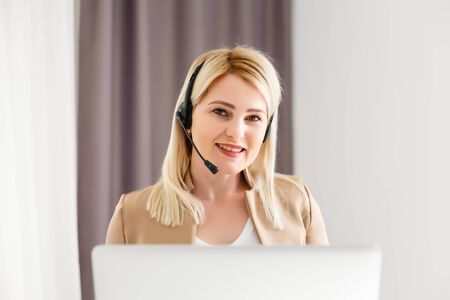 Close up portrait of a beautiful young woman smiling and looking at laptop screenの写真素材