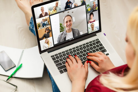 View over girl shoulder, use webcam and laptop enjoy distant communication with family. Diverse...