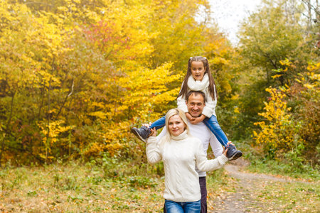 Family with child go in autumn park