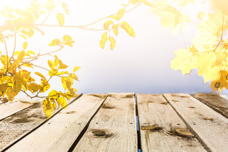 Empty wooden table with autumn for a catering or food background with a country outdoor...