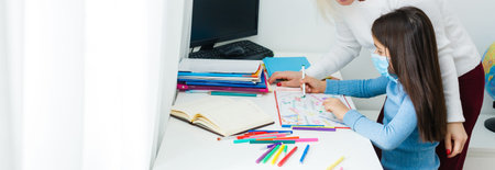 A small girl with her mother are making exercises in copybook at distance home schooling, quarantine