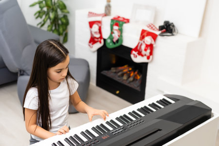 little girl playing electric piano at christmasの写真素材