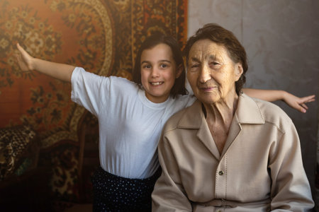 Little baby girl and very old woman. Little child hugging grandmother. Granddaughter