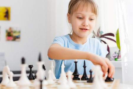 Girl moving a counter while playing chessの写真素材