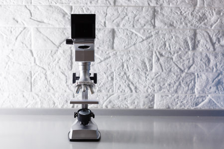 microscope stands on a table on a white backgroundの写真素材
