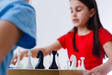 Two cute children playing chess at homeの写真素材