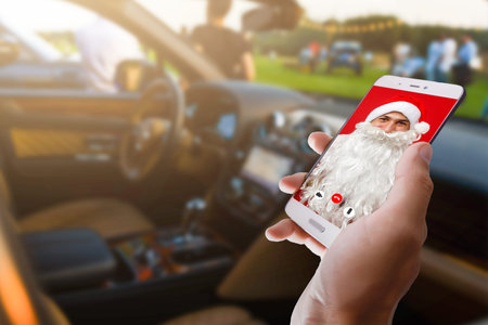 Santa Claus calls on a smartphone and makes a video greeting with New Year and Merry Christmas.の写真素材