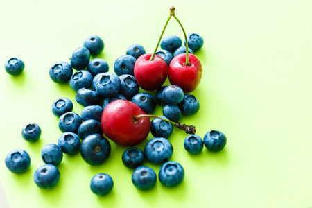 Many fresh blueberries on green-yellow background