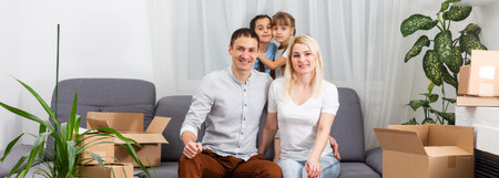 Smiling young parents and their children are very happy, they are at home