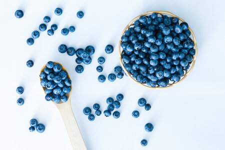Freshly picked blueberries in wooden bowl. fresh blueberries on a white rustic table. selective focus.の写真素材