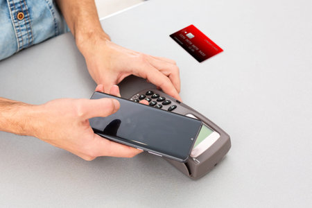 Payment on a trade through contactless card and NFC technology. Front view. Horizontal composition.