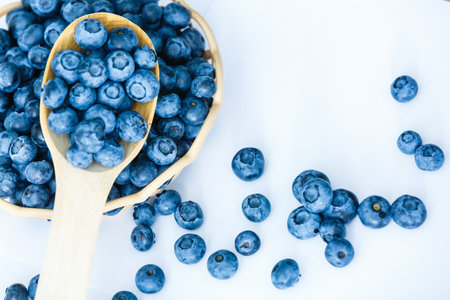 Freshly picked blueberries in wooden bowl. fresh blueberries on a white rustic table. selective focus.の写真素材
