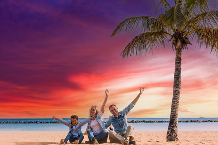 happy family hands up on the beachの写真素材