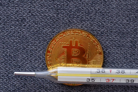 Mercury thermometer and bitcoin on white background