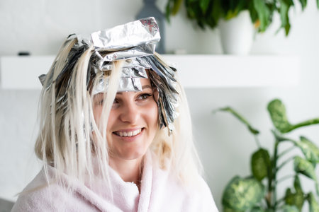 woman dyes her hair foil at homeの写真素材