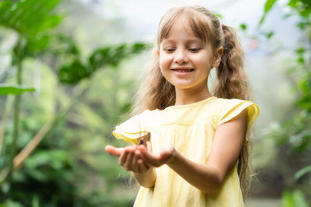 Little girl holding butterfly in her hand.の写真素材