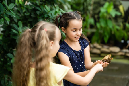 two little girls with butterflies in a greenhouseの写真素材