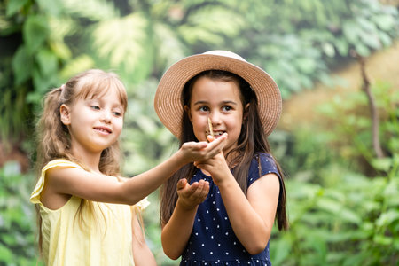 two little girls with butterflies in a greenhouseの写真素材