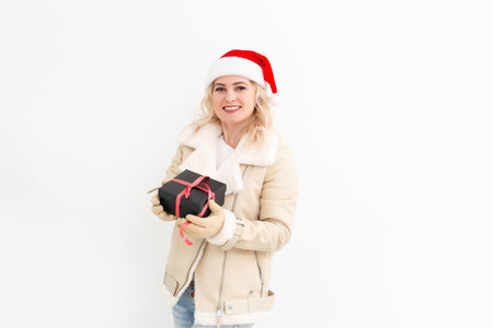 Woman in winter clothes with gifts, presents, smilingの写真素材