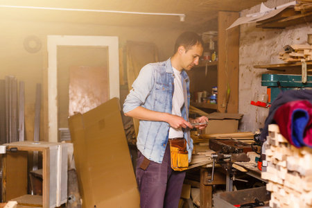 handsome joiner work in carpentry. He is successful entrepreneur at his workplace.の写真素材