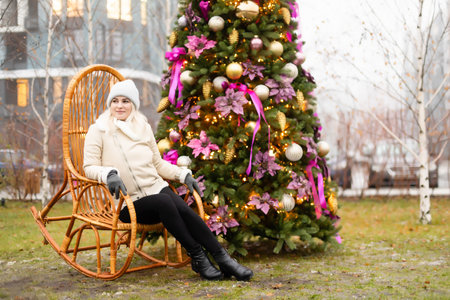 woman and photo zone christmas tree and rocking chair on the streetの写真素材