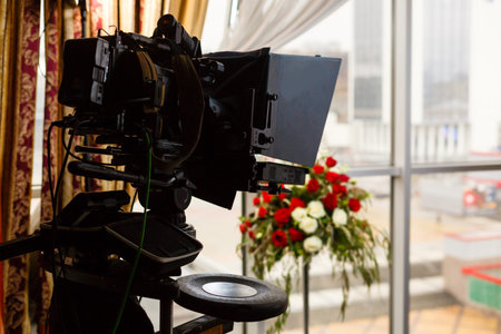 Professional camcorder, video camera, black silhouette of camera on blue background, close up