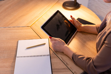 A happy woman girl works remotely from home and communicates via video call with friends and relatives in her office. Distance learning and work online. Using the tabletの写真素材