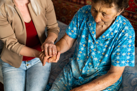 Young woman holding senior womans hand