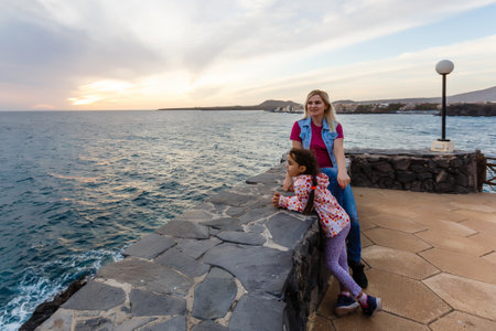 Family holiday on Tenerife, Spain. Mother with children outdoors on ocean. Portrait travel tourists - mom with kids. Positive human emotions, active lifestyles. Happy young family on sea beachの写真素材
