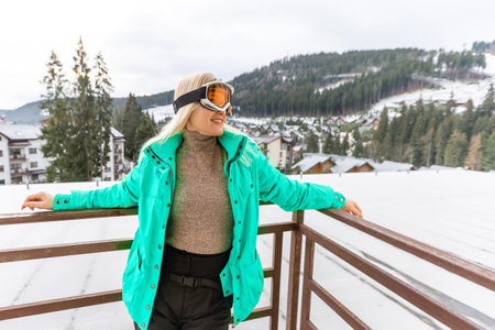 Woman relaxing on terrace on mountain, snow on hills.の写真素材