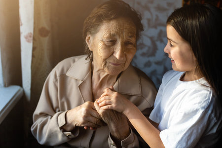 Little baby girl and very old woman. Little child hugging grandmother. Granddaughterの写真素材